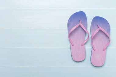 Tahta arka planda parlak parmak arası terlikler, üst görünüm
