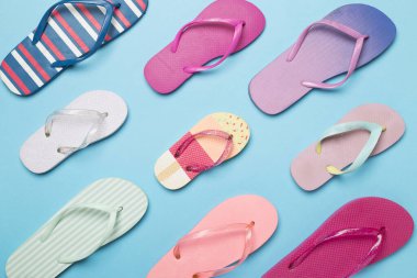 Renk arkaplanı ve üst görünümde birçok parlak parmak arası terlik