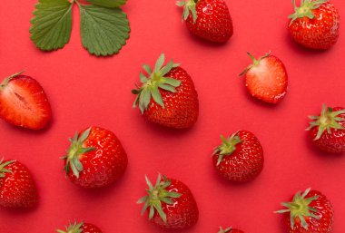 Renkli arka planda yaprakları olan çilekler, üst görünüm