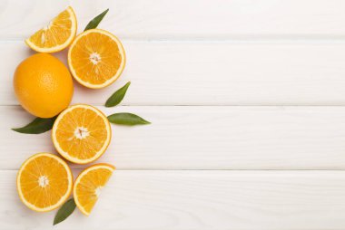 Flat lay with fresh oranges and leaves on wooden background