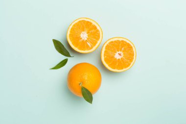 Flat lay with fresh oranges and leaves on color background