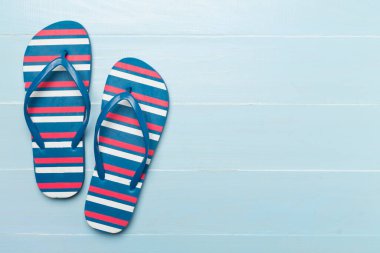 Tahta arka planda parlak parmak arası terlikler, üst görünüm