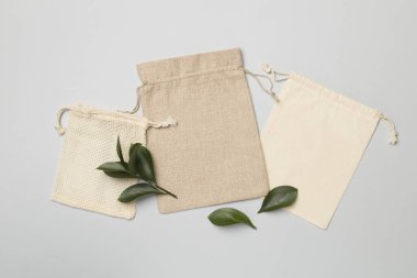 Small eco sacks with green leaves color on background. Top view