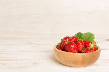 Tahta masada kasede taze çilekler.