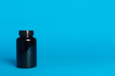 Renk arkaplanındaki vitaminler için plastik şişe