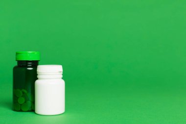 Renk arkaplanındaki vitaminler için plastik şişeler