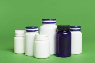 Renk arkaplanındaki vitaminler için plastik şişeler