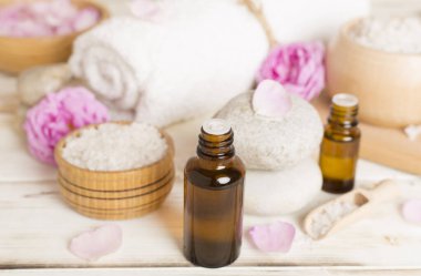 Ahşap masanın üzerinde pembe güller olan spa kompozisyonu