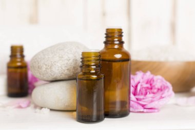 Ahşap masanın üzerinde pembe güller olan spa kompozisyonu