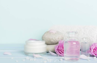 Ahşap masanın üzerinde pembe güller olan spa kompozisyonu