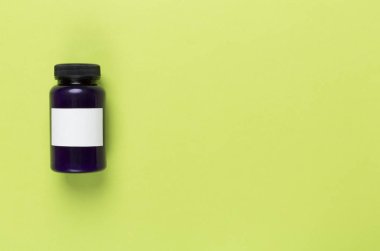 Renkli arka planda vitaminler olan plastik şişe, üst görünüm