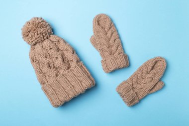 Kahverengi kış şapkası ve eldivenleri renkli arka planda. Üst görünüm.