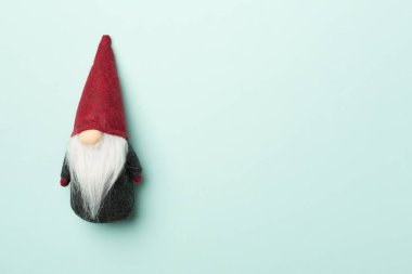 Renkli arka planda küçük bir Noel cücesi, üst görünüm.