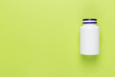 Renkli arka planda vitaminler olan plastik şişe, üst görünüm