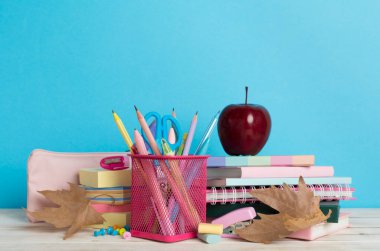 Ahşap masa üzerinde kitap ve kırtasiye malzemesi olan kompozisyon. Okul konseptine dönelim.