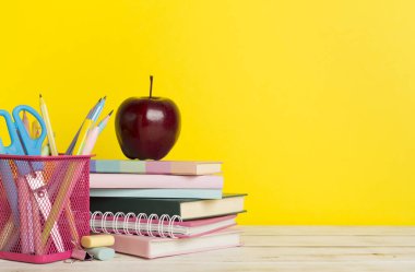 Ahşap masa üzerinde kitap ve kırtasiye malzemesi olan kompozisyon. Okul konseptine dönelim.