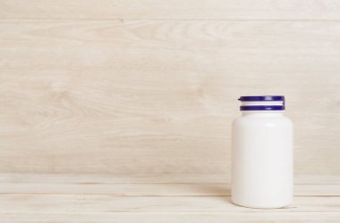 Tahta masadaki vitaminler için plastik şişe.