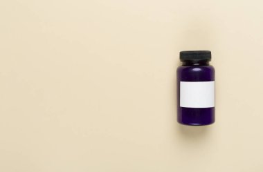 Renkli arka planda vitaminler olan plastik şişe, üst görünüm