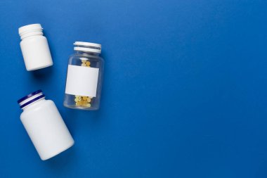 Renkli arka planda vitaminleri olan plastik şişeler, üst görünüm