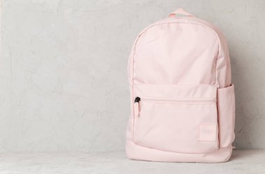 Beton masada pembe okul çantası.