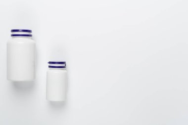 Beyaz arka planda vitaminleri olan plastik şişeler.