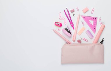 Renkli arka plan üzerinde okul kırtasiyesi olan pembe kalem kutusu, üst görünüm