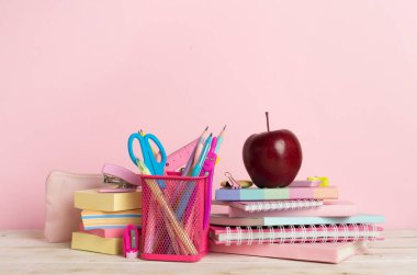 Ahşap masa üzerinde kitap ve kırtasiye malzemesi olan kompozisyon. Okul konseptine dönelim.