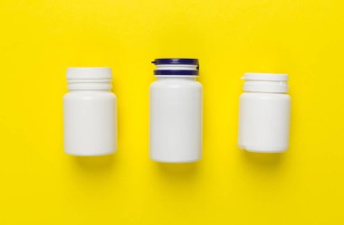 Renkli arka planda vitaminleri olan plastik şişeler, üst görünüm