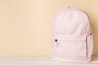 Ahşap masada pembe okul çantası.