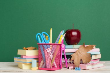 Ahşap masa üzerinde kitap ve kırtasiye malzemesi olan kompozisyon. Okul konseptine dönelim.