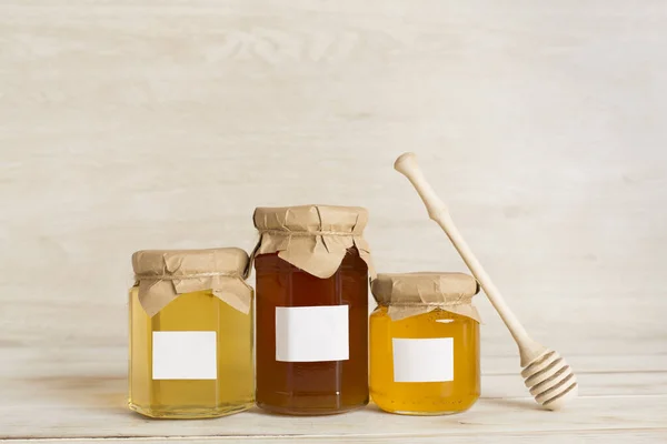Jars with honey on wooden table. Mock up design