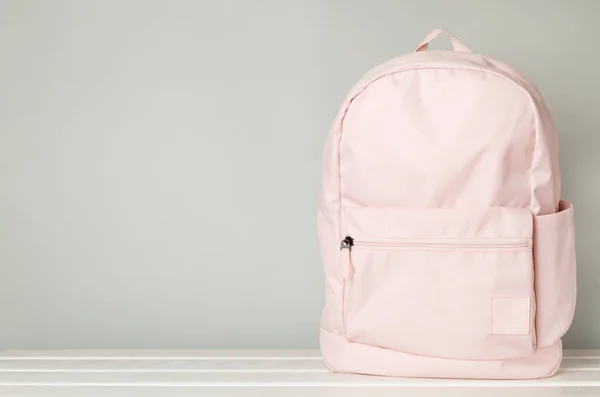 Pink school backpack on concrete table