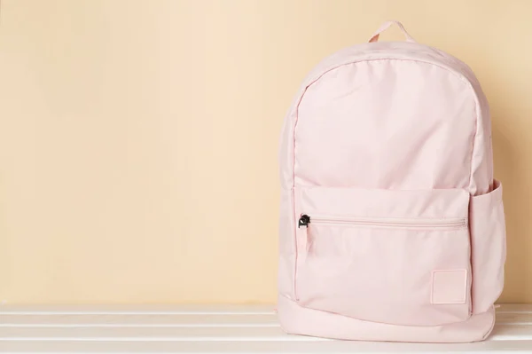 Pink school backpack on wooden table