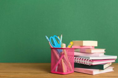 Ahşap masa üzerinde kitap ve kırtasiye malzemesi olan kompozisyon. Okul konseptine dönelim.