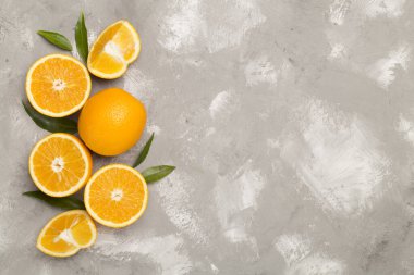 Beton zemin üzerinde yaprakları olan taze portakallar.