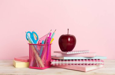 Ahşap masa üzerinde kitap ve kırtasiye malzemesi olan kompozisyon. Okul konseptine dönelim.