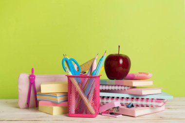 Ahşap masa üzerinde kitap ve kırtasiye malzemesi olan kompozisyon. Okul konseptine dönelim.