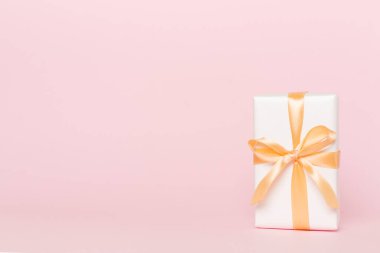 Kırmızı kurdeleli hediye kutusu ışık masasında..