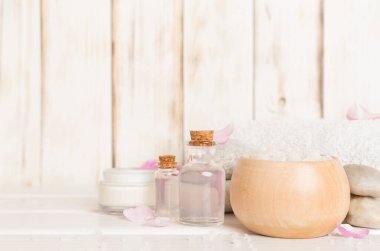 Ahşap masanın üzerinde pembe güller olan spa kompozisyonu