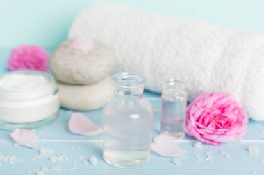 Ahşap masanın üzerinde pembe güller olan spa kompozisyonu