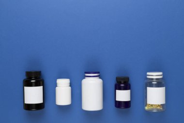 Renkli arka planda vitaminleri olan plastik şişeler, üst görünüm