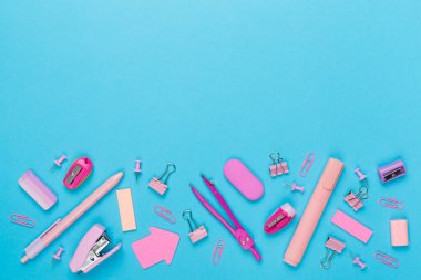 Renkli arka plan üzerine pembe okul kırtasiyesi, üst görünüm