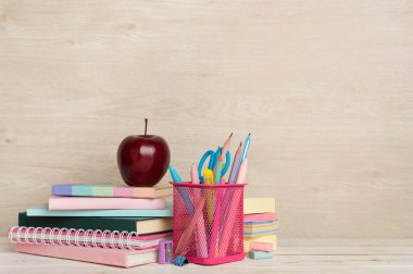 Ahşap masa üzerinde kitap ve kırtasiye malzemesi olan kompozisyon. Okul konseptine dönelim.