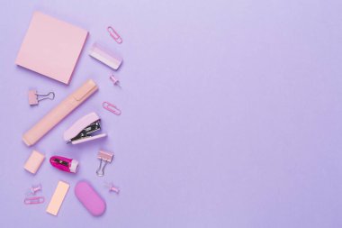 Renkli arka plan üzerine pembe okul kırtasiyesi, üst görünüm