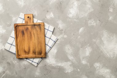 Beton zemin üzerinde havlu ile kesme tahtası, üst görünüm.