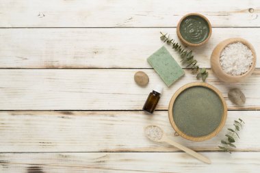 Ahşap arka planda kozmetik kil ve spa ürünleri ile kompozisyon, üst görünüm