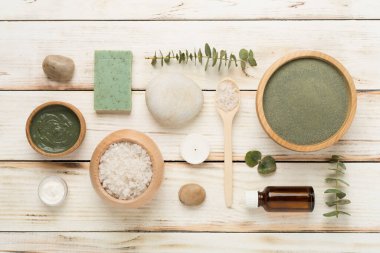 Ahşap arka planda kozmetik kil ve spa ürünleri ile kompozisyon, üst görünüm