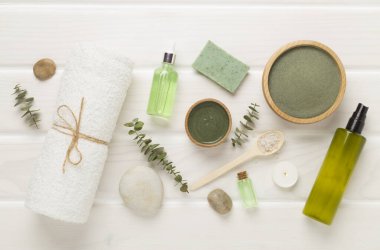 Ahşap arka planda kozmetik kil ve spa ürünleri ile kompozisyon, üst görünüm