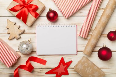 Gift boxes, paper's rools and decorations on wooden background, top view.