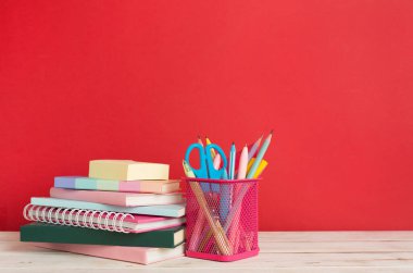 Ahşap masa üzerinde kitap ve kırtasiye malzemesi olan kompozisyon. Okul konseptine dönelim.